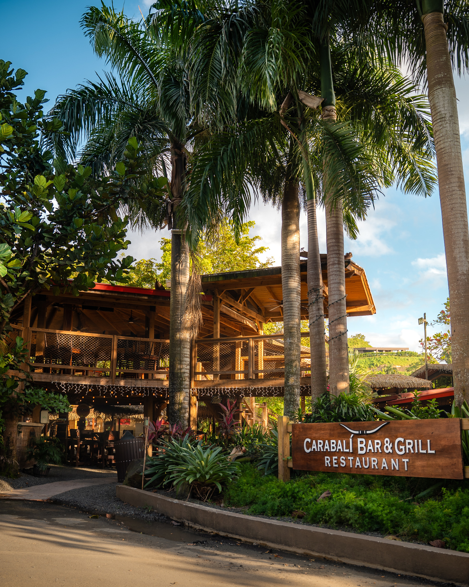 Tropical restaurant with palm trees and Carabali Bar & Grill sign.