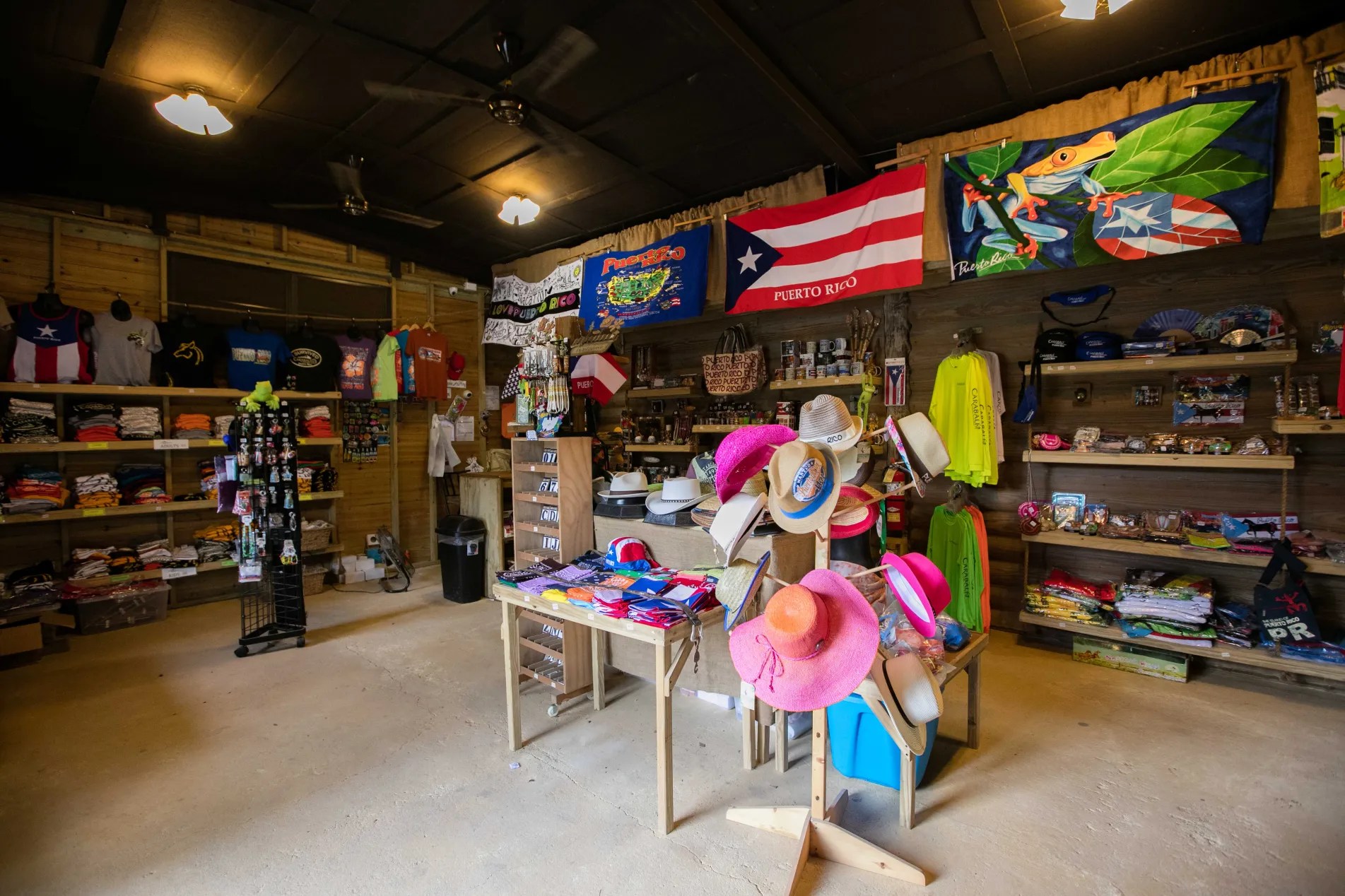 Gift shop interior with colorful hats, clothing, and flags on display.